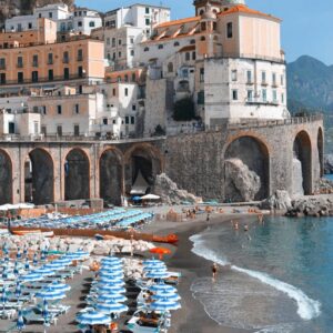 A view of the Atrani Beach Coastline with Atrani beach club and beach umbrellas on the Amalfi Coast, Italy.