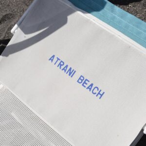 A beach lounger on the black sand beach at Atrani, Italy, Amalfi Coast.