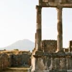 An ancient column at Pompeii, Italy with Mount Vesuvius visible in the background.