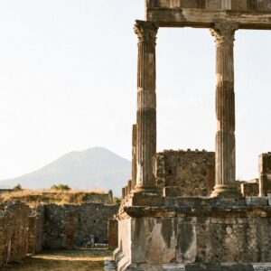 An ancient column at Pompeii, Italy with Mount Vesuvius visible in the background.
