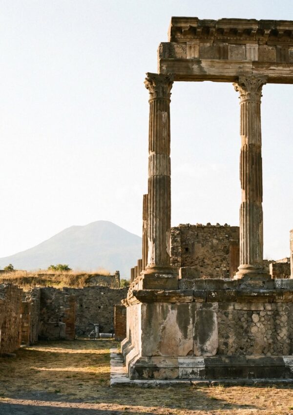 An ancient column at Pompeii, Italy with Mount Vesuvius visible in the background.