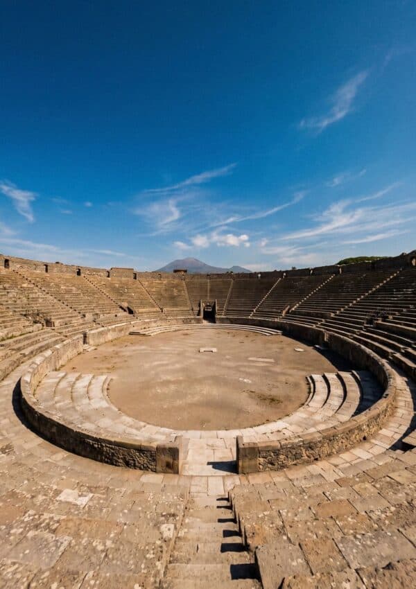A large amphitheater with stone seating at the ancient ruins of Pompeii.