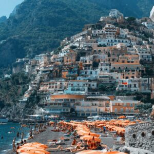 A view of Spiaggia Grande and the city of Positano on the Amalfi Coast with the mountains behind it.