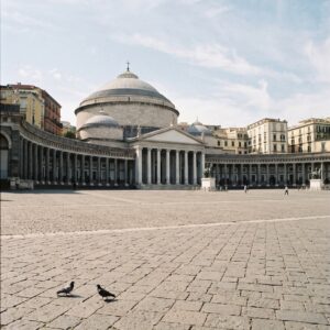 Wide view of Piazza del Plebiscito in Naples with pigeons in the foreground
