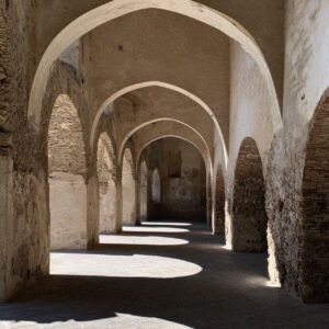 Sunlight falling through a vaulted stone arcade in Amalfi