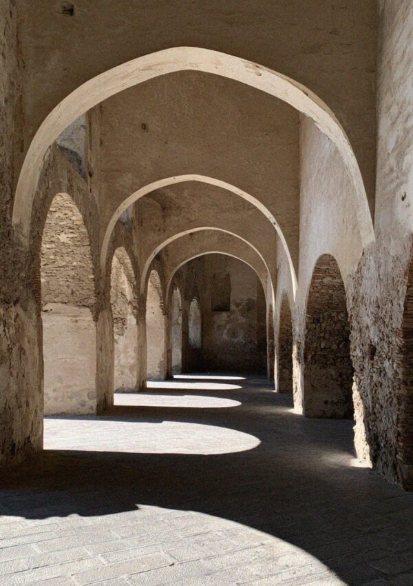 Sunlight falling through a vaulted stone arcade in Amalfi