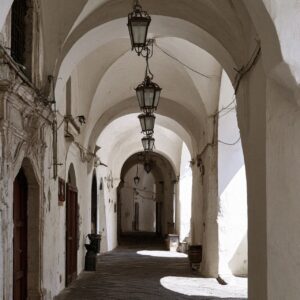 A vaulted covered stone arcade with a hanging lantern in Amalfi