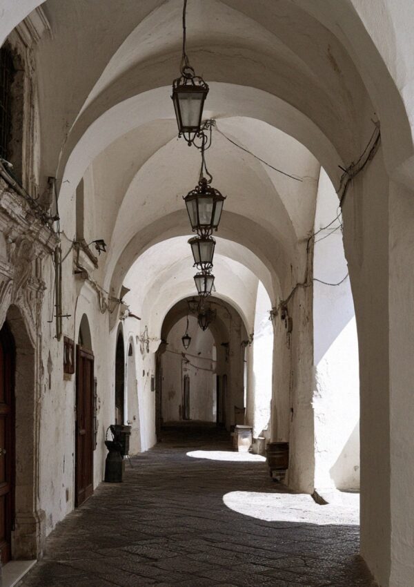 A vaulted covered stone arcade with a hanging lantern in Amalfi