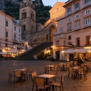 Cafe tables in an Amalfi piazza lit up in the evening
