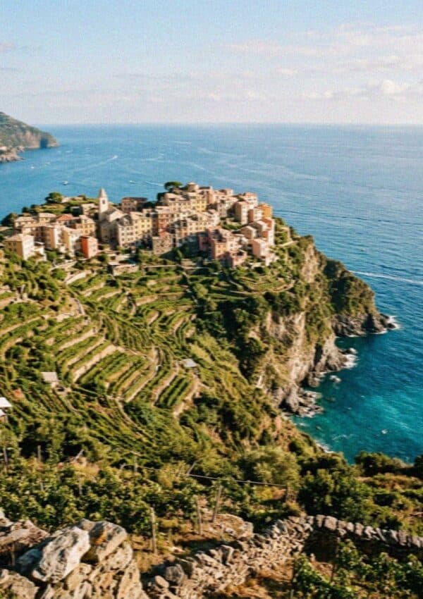 The hilltop village of Corniglia in Cinque Terre perched on a green terraced headland above the sea