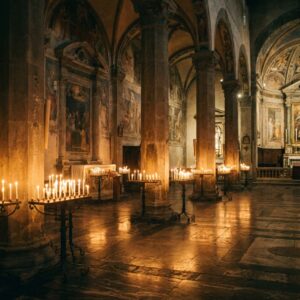 The candlelit stone interior of a Florentine church