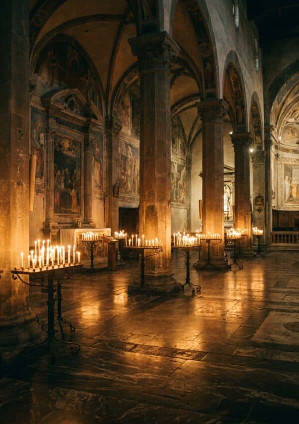 The candlelit stone interior of a Florentine church