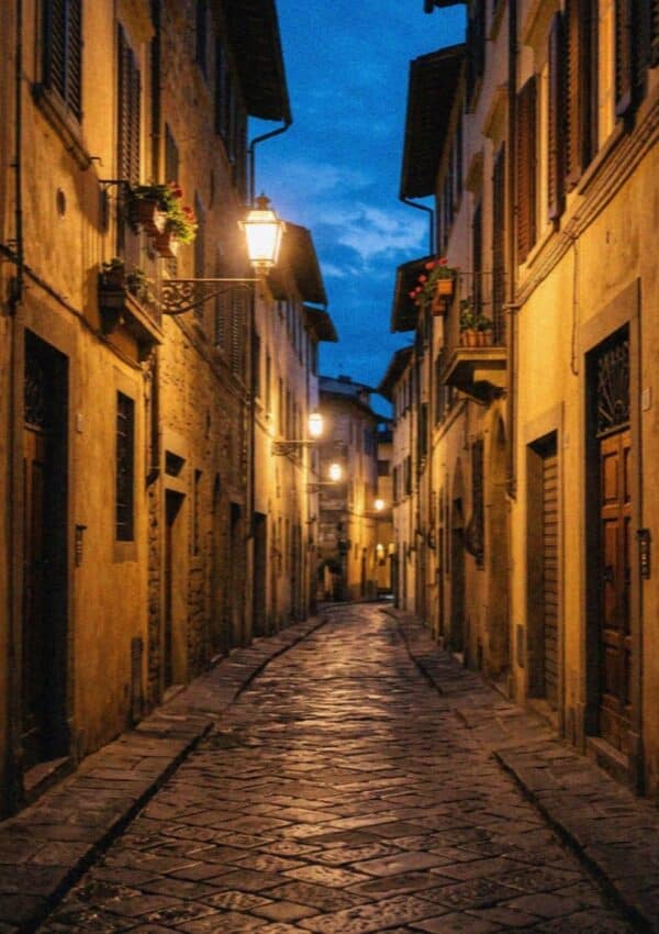 A lamplit cobblestone lane in Florence at blue hour