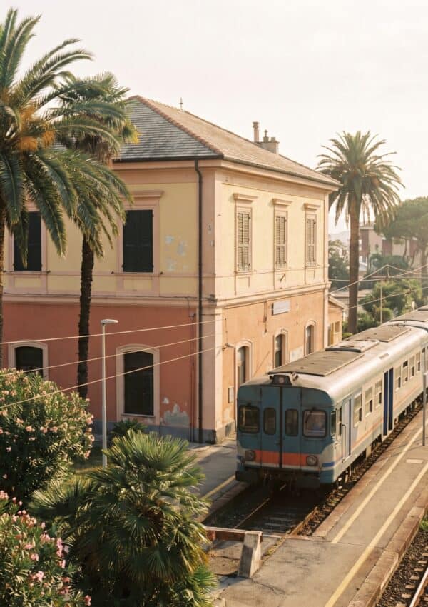 The pastel Santa Margherita Ligure railway station with a regional train and palms