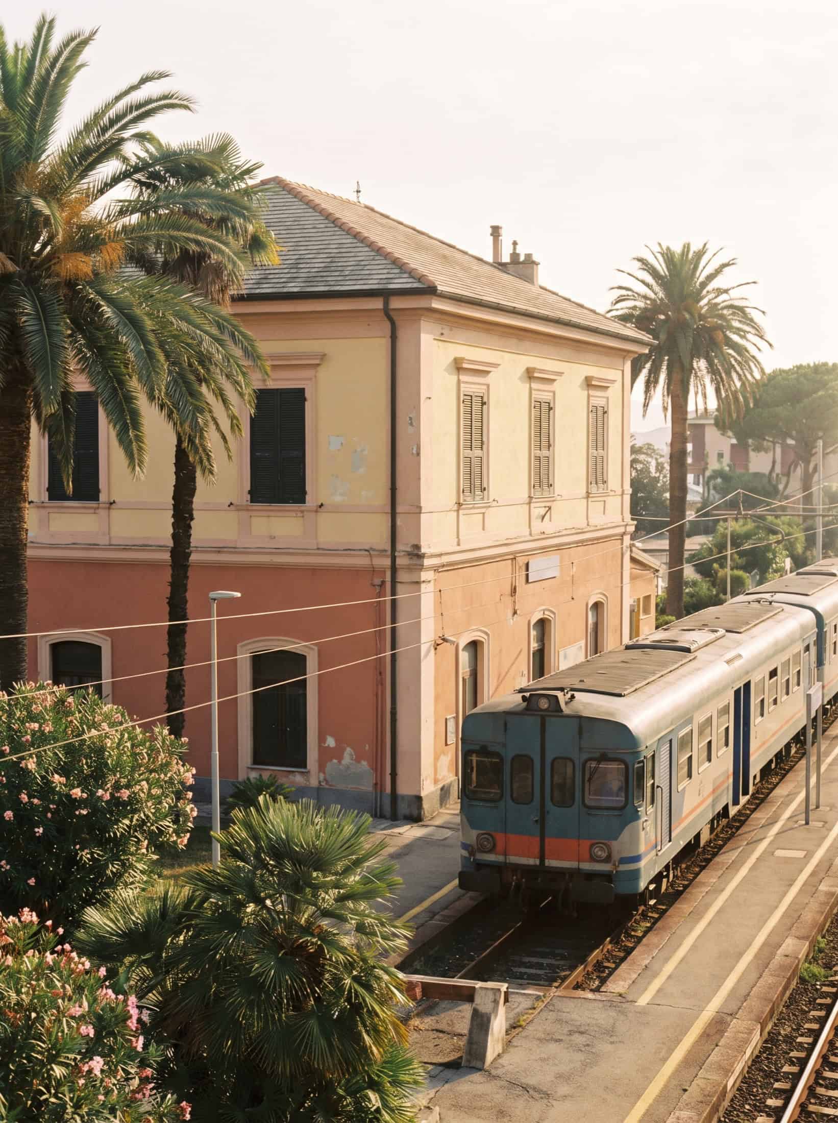 The pastel Santa Margherita Ligure railway station with a regional train and palms