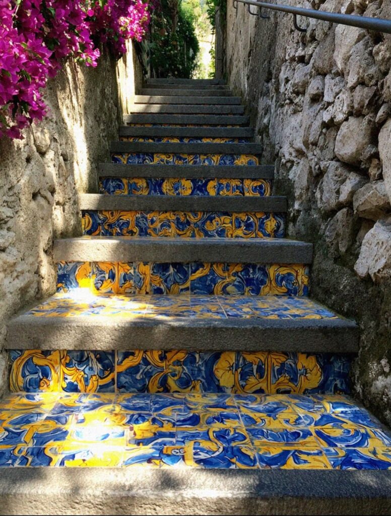 Ceramic tiled staircase with blue and yellow majolica tiles and pink bougainvillea in Ravello Italy