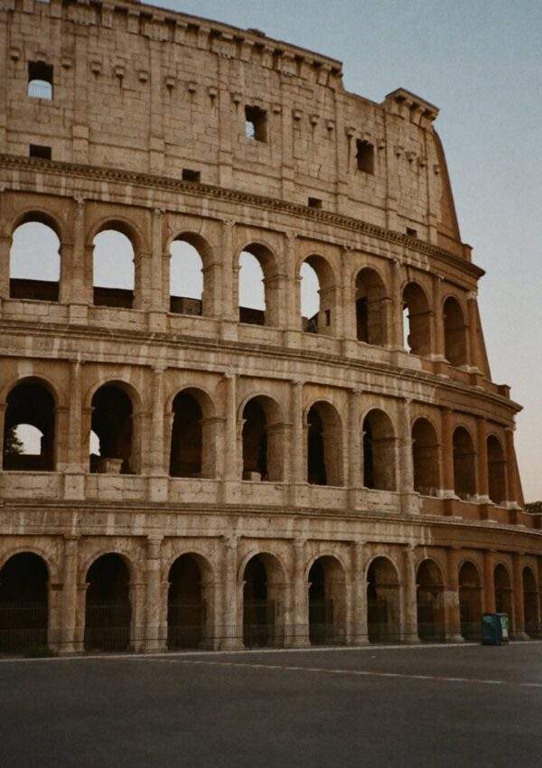 The exterior arches of the Colosseum in Rome catching the last light at dusk