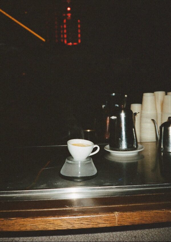 An espresso cup on a bar counter in Rome at night
