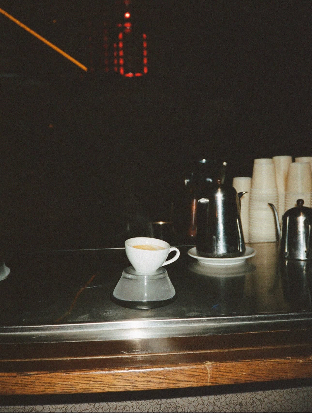 An espresso cup on a bar counter in Rome at night