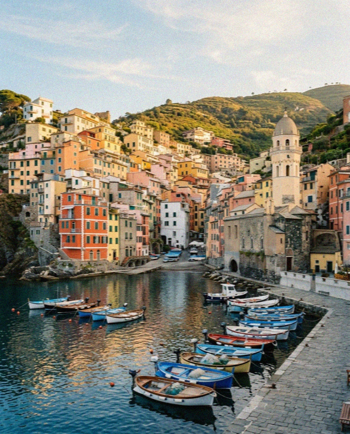 The harbour of Vernazza in Cinque Terre with fishing boats and the church