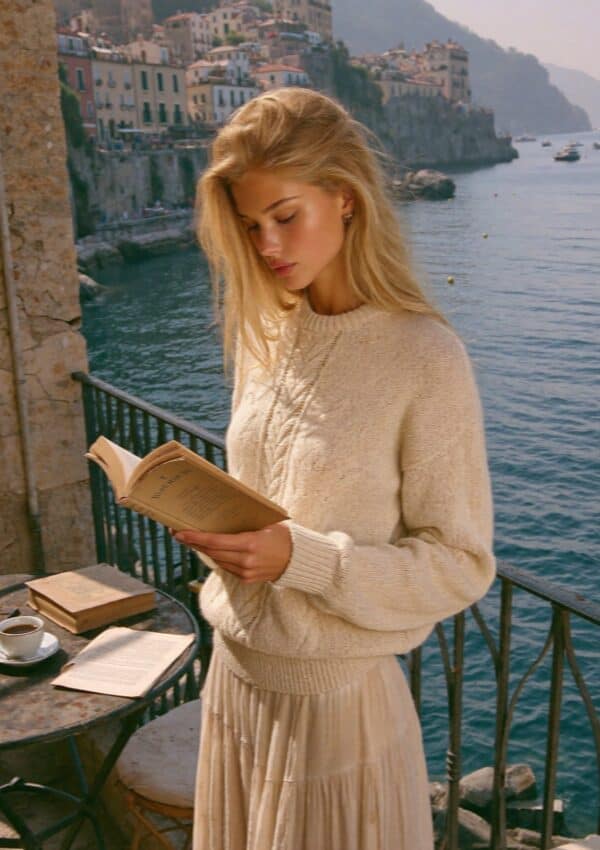 Victoria Van Der Berg reading on a balcony terrace overlooking the Amalfi Coast