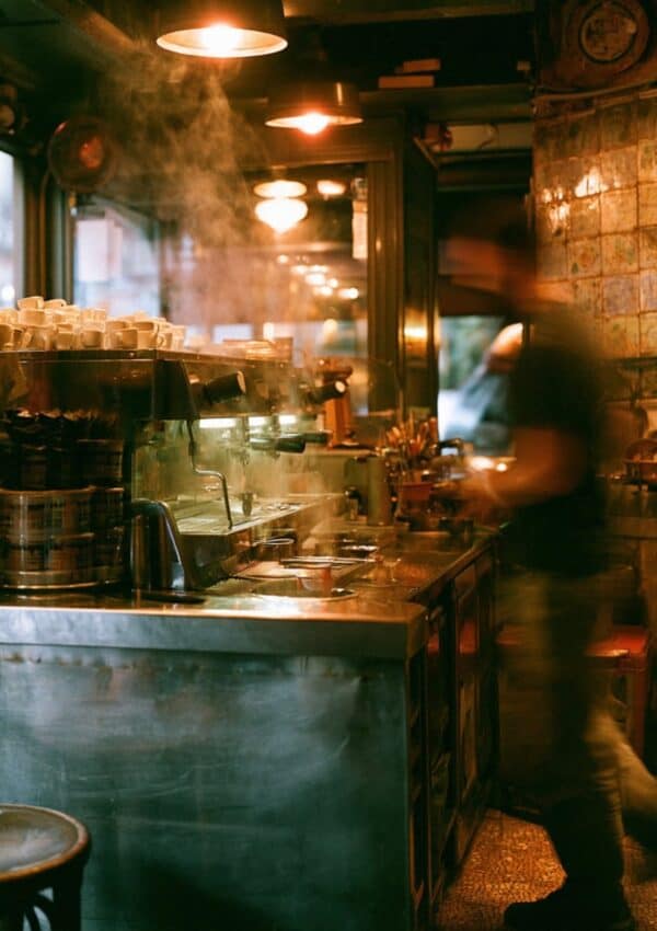 Steam rising inside a historic Naples espresso bar with a barista working at the machine