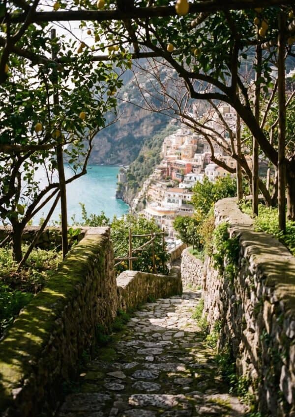 Victoria Van Der Berg in a white dress standing on a cliffside above the Amalfi Coast near Positano