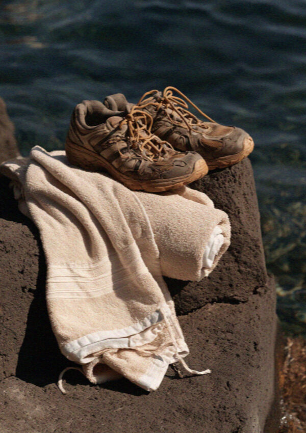Water shoes on hot volcanic stone beside the sea in the Aeolian Islands