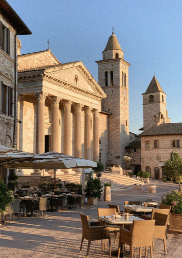 Piazza del Comune in Assisi with the Roman Temple of Minerva facade and a medieval tower