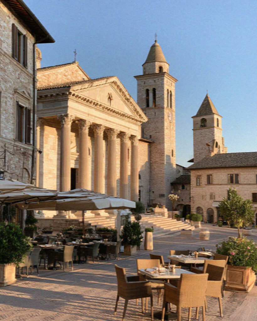Piazza del Comune in Assisi with the Roman Temple of Minerva facade and a medieval tower