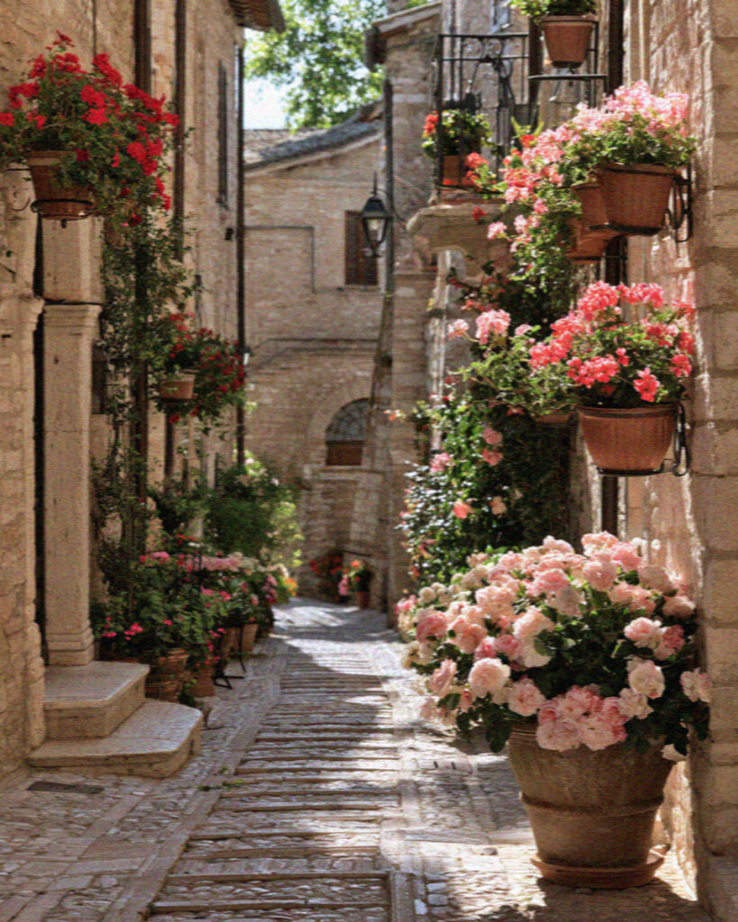 A flower-filled medieval alley in Spello near Assisi hung with geraniums