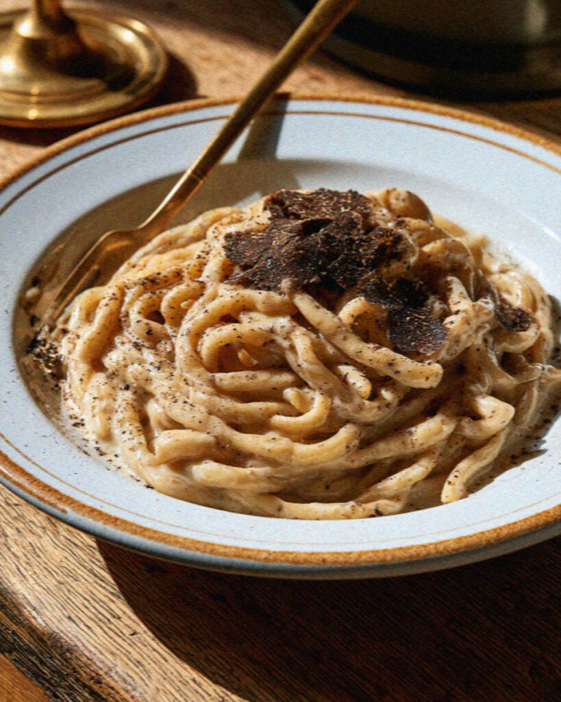 Umbrian strangozzi pasta with shaved black truffle on a rustic ceramic plate