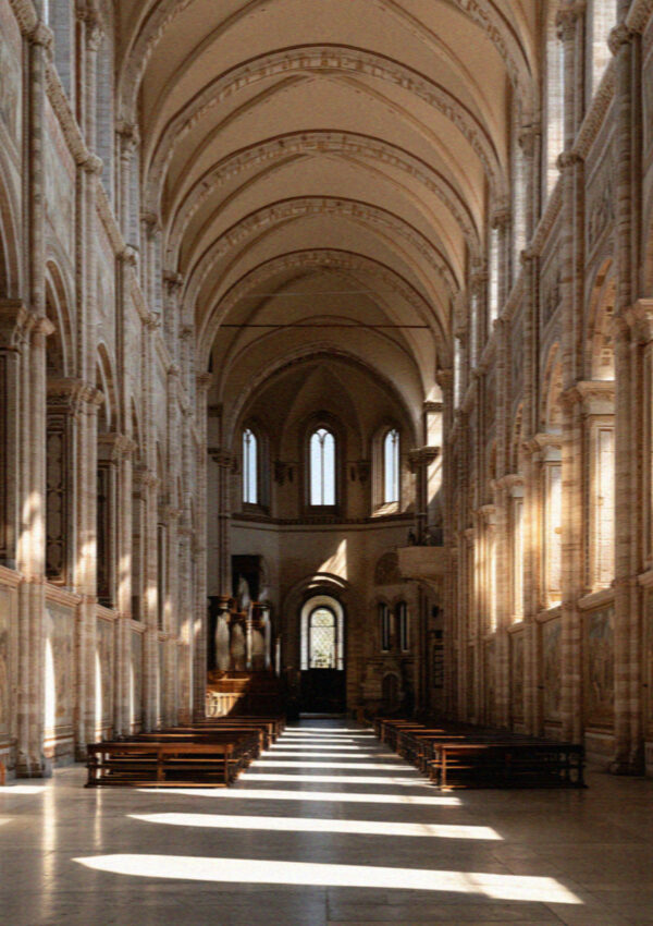 The tall bright single-aisle nave of the Upper Basilica in Assisi with daylight falling across the floor
