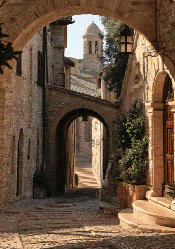 Via San Francesco in Assisi, a sloping street of pale stone arches leading to the Basilica