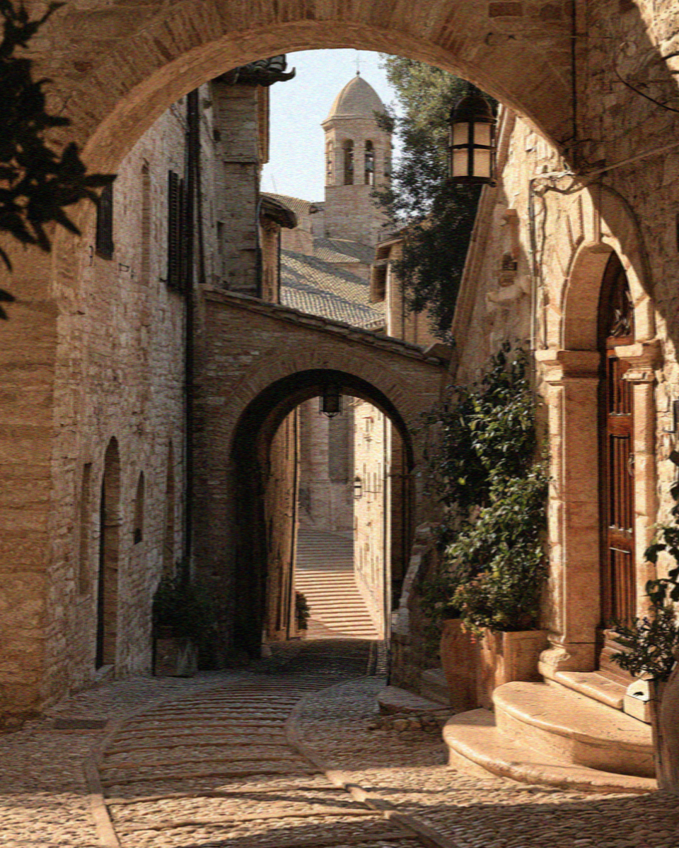 Via San Francesco in Assisi, a sloping street of pale stone arches leading to the Basilica