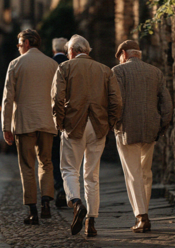 Old men in jackets walking a lane in Bergamo