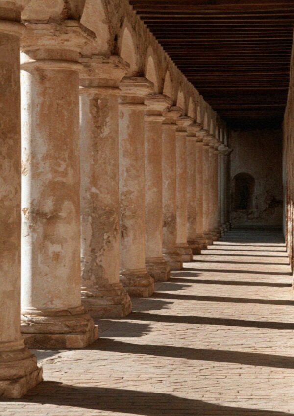A long stone colonnade in Bologna in the morning light