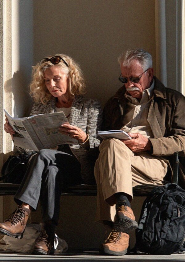 An older couple reading on a bench in Bologna