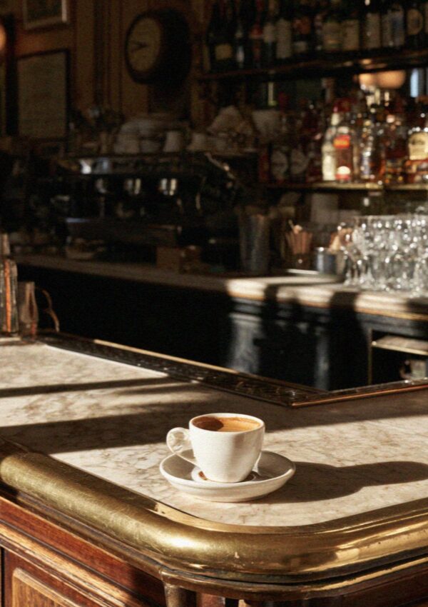An espresso on a brass and marble bar counter in Bologna