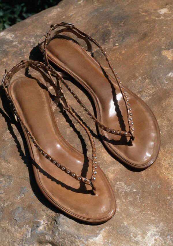A pair of leather sandals on warm stone in Bologna