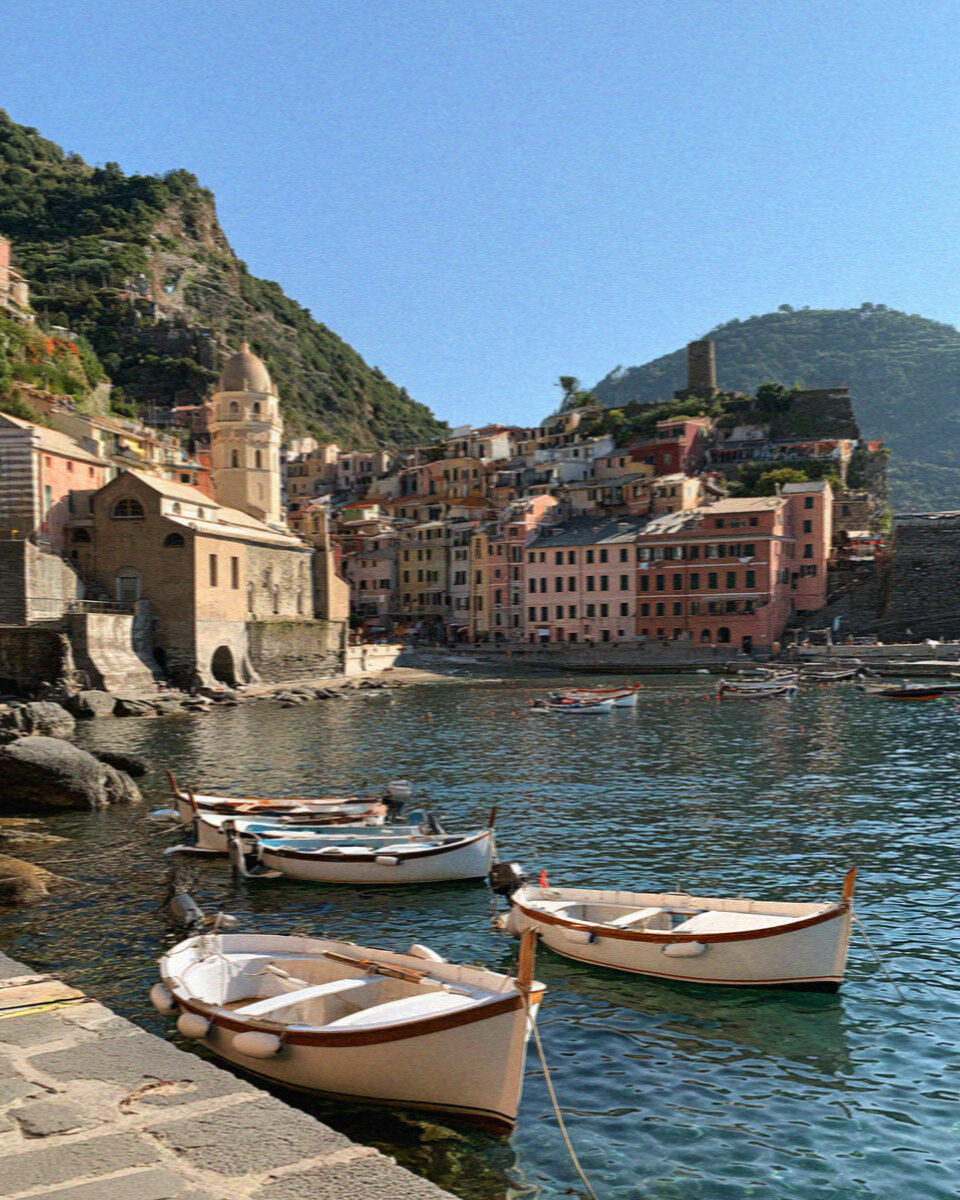 The harbour of Vernazza in the Cinque Terre with pastel houses above a small port