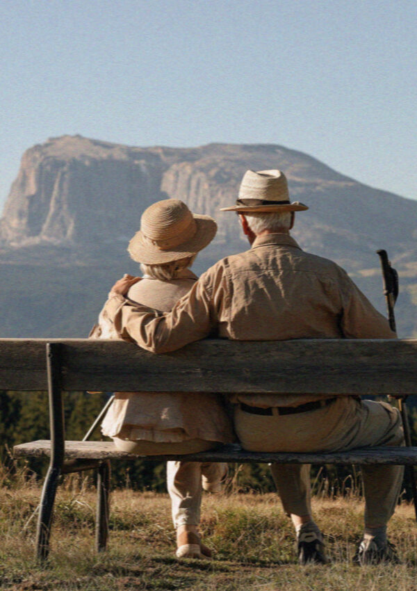 An older couple on a bench looking at the Sciliar in the Dolomites