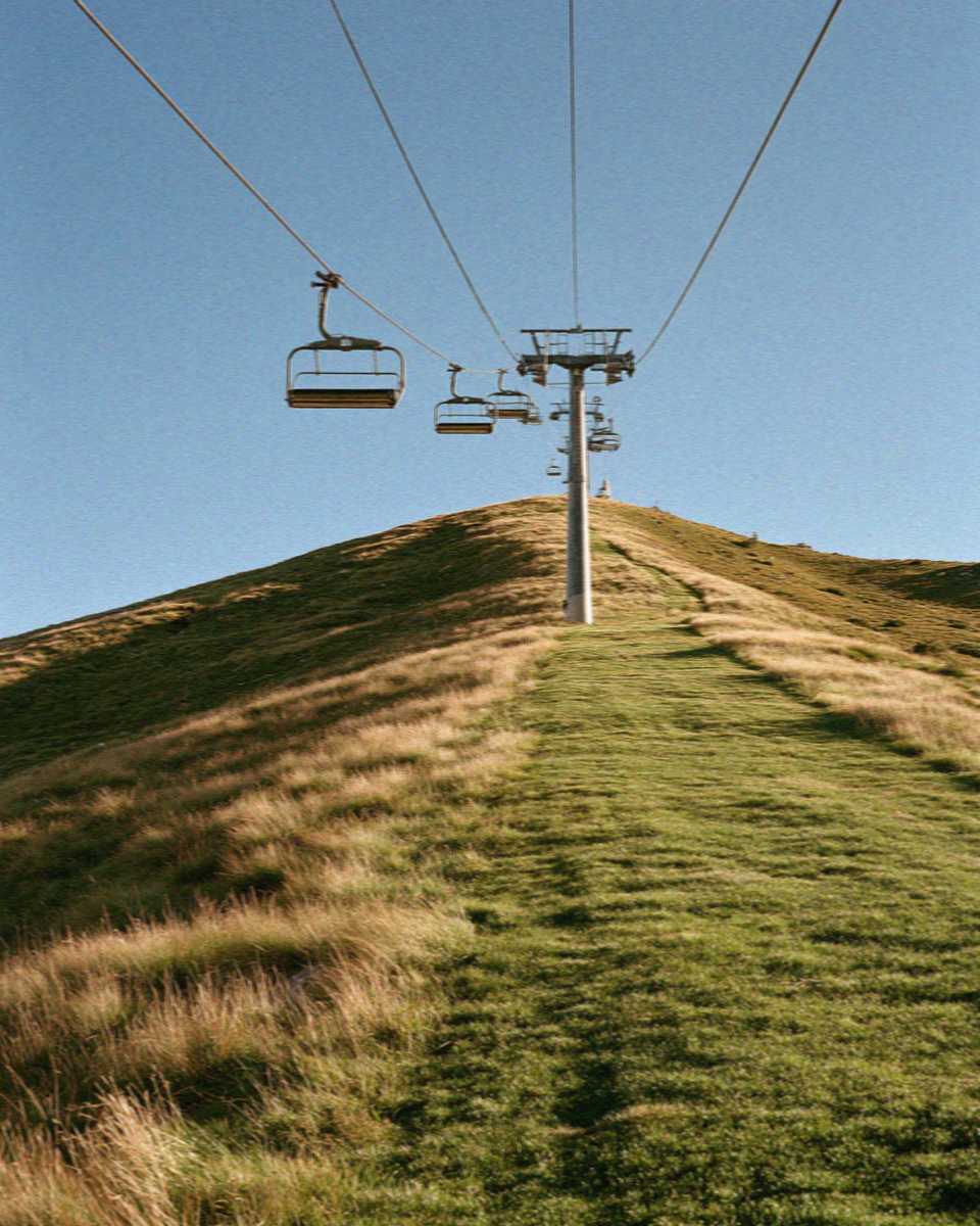 A chairlift climbing a grassy ridge in the Dolomites