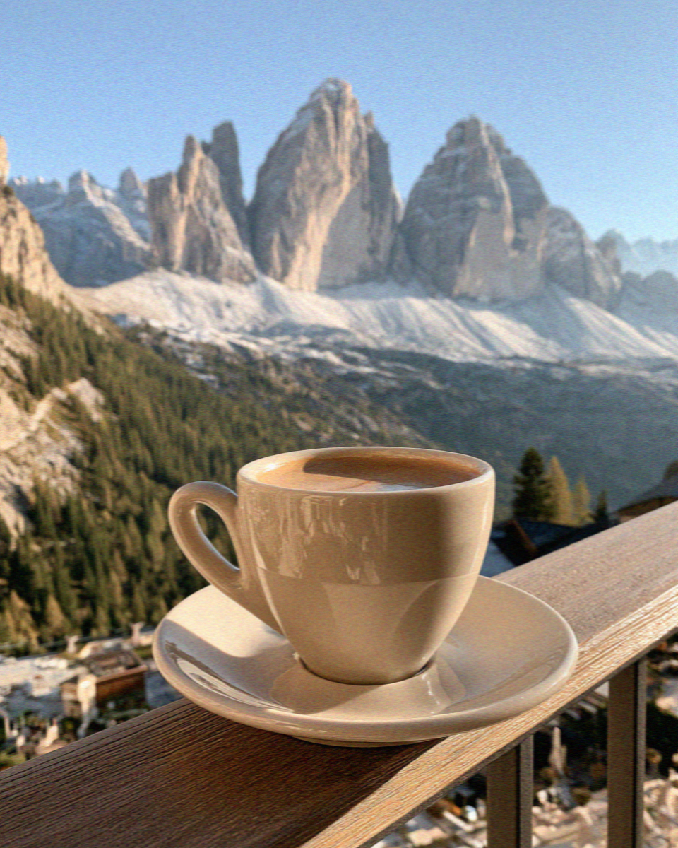 An espresso on a terrace railing with the Tre Cime beyond