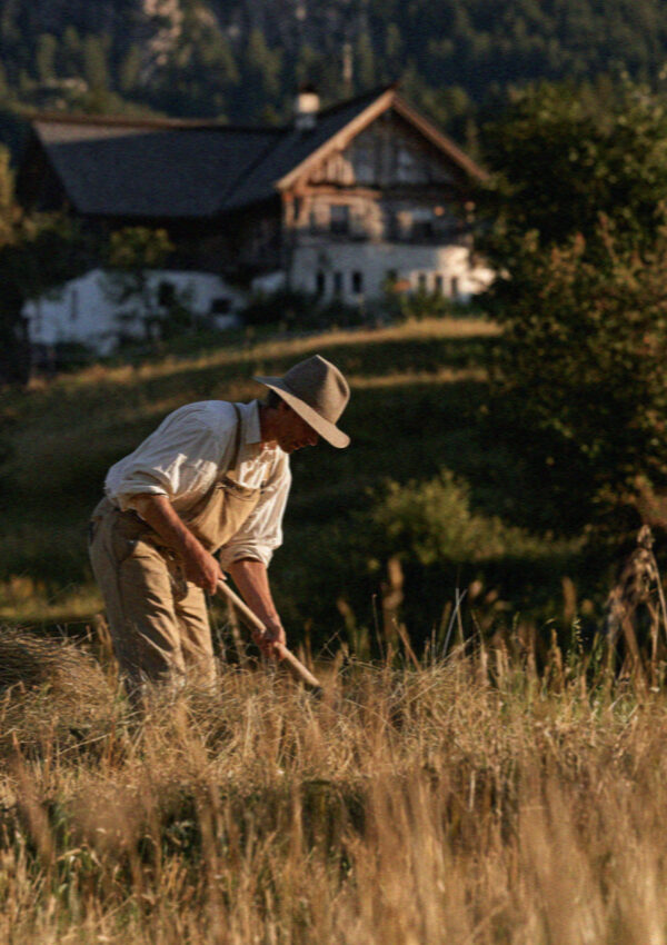 A South Tyrolean farmer haymaking near a maso in the Dolomites