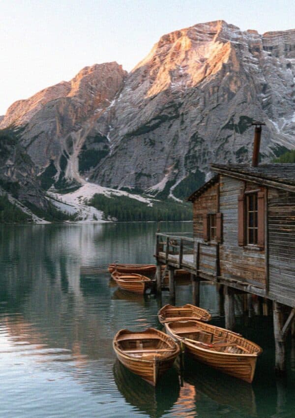 The boathouse and emerald water of Lago di Braies in the Dolomites