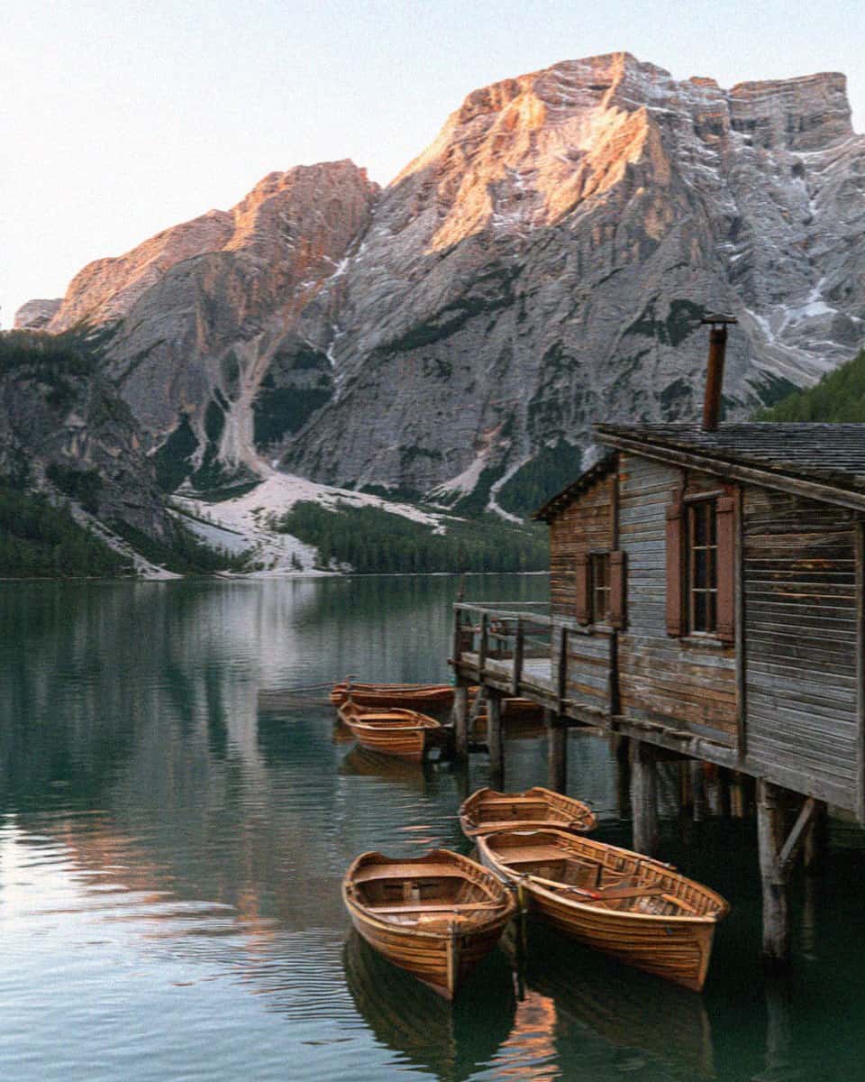The boathouse and emerald water of Lago di Braies in the Dolomites