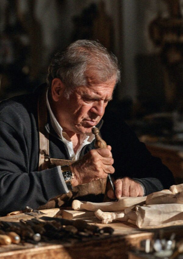 A woodcarver at his bench in Ortisei, Val Gardena, Dolomites