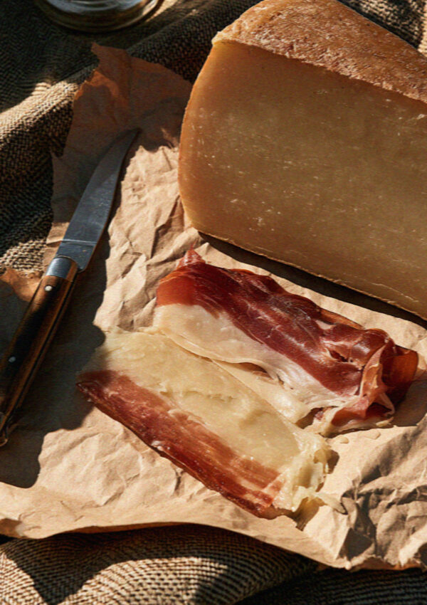 Speck and mountain cheese on paper at a Dolomites picnic