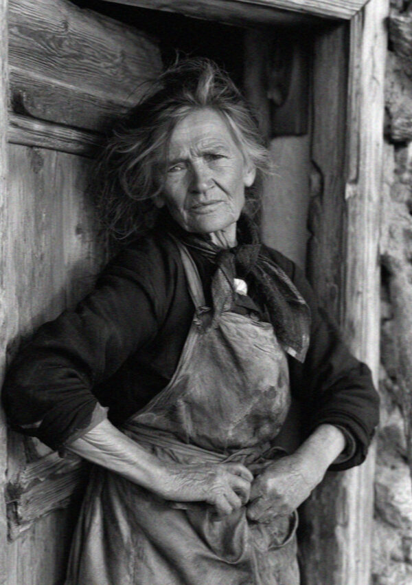 An older South Tyrolean woman at a maso door in the Dolomites